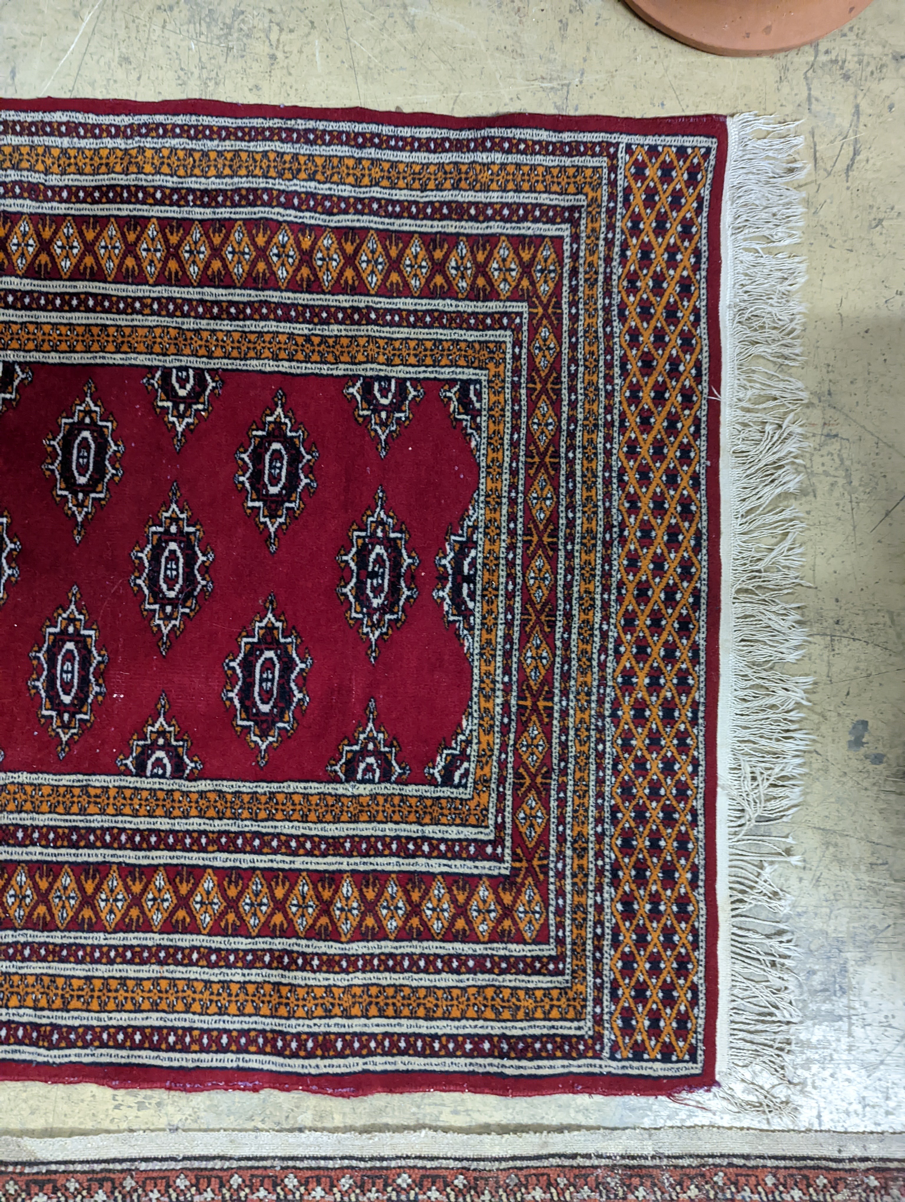 A Bokhara red ground rug, 155 x 88cm